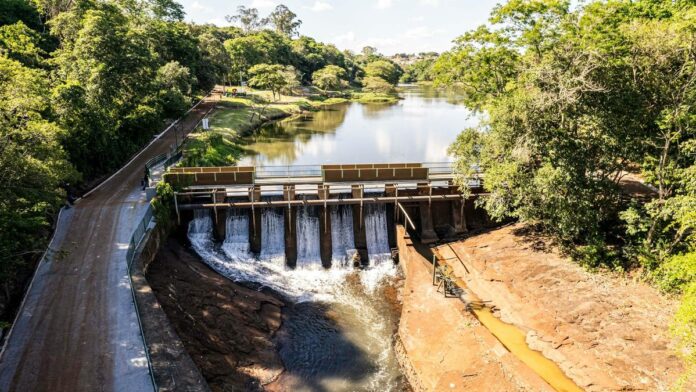 Scenic aerial view of a dam and lush lake in Londrina, Paraná, Brazil, during a bright summer day.