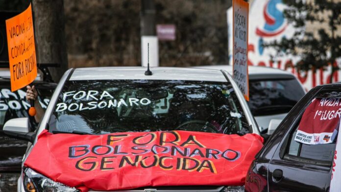 Cars displaying anti-Bolsonaro signs during a street protest, highlighting political activism.