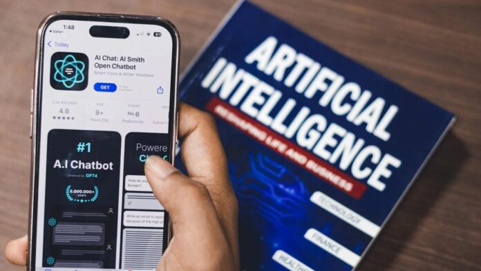 Smartphone displaying AI app with book on AI technology in background.