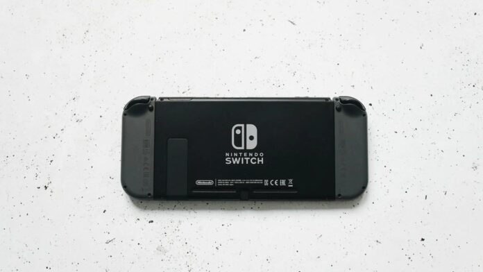 s4-a7b3d7600275-1 A close-up of a Nintendo Switch console placed on a textured marble surface, highlighting the device's sleek design.
