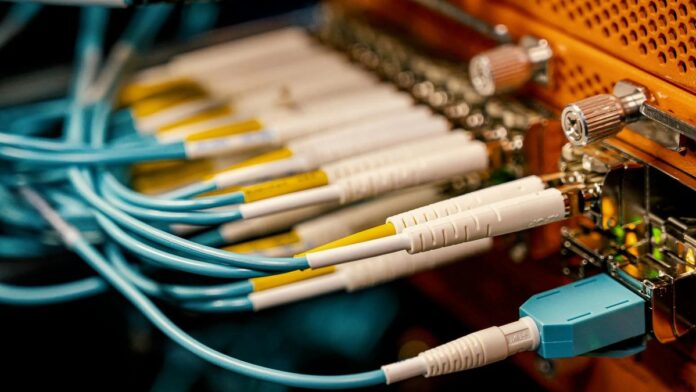 From above of optical switch equipment with many similar connectors with rubber cables and metal parts