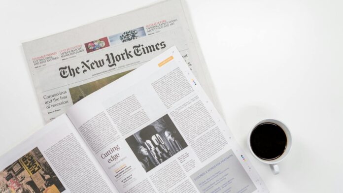 Flat lay of a coffee cup and The New York Times newspaper, ideal for business and lifestyle themes.