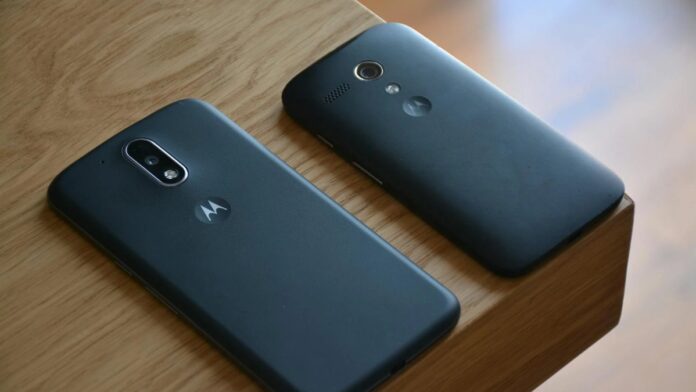 Two Motorola smartphones placed on a wooden table with natural lighting.