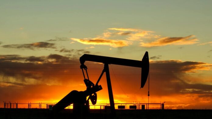 Dramatic silhouette of an oil pump jack against a vibrant sunset sky, emphasizing energy extraction.