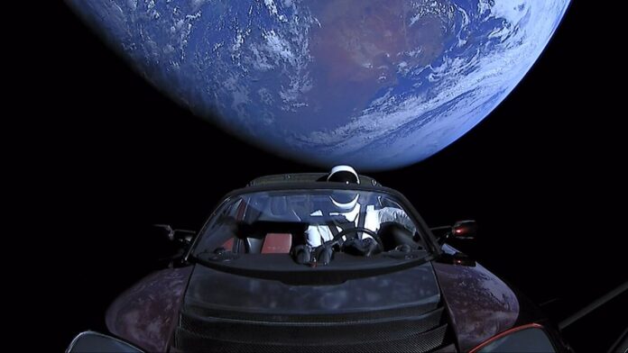 Elon Musk's Tesla Roadster, with Earth in background. "Starman" mannequin wearing SpaceX Spacesuit in driving seat. Camera