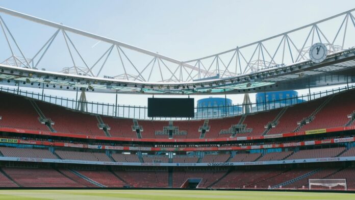 s4-d9f9d348da19-2 A view of the empty Emirates Stadium, home of Arsenal FC, under a clear sky in London.