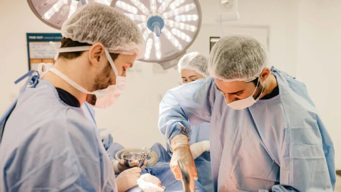 Team of surgeons working diligently in a well-lit operating room setting.