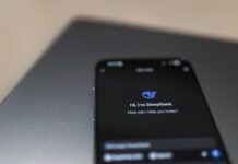 Notebooks com IA valem o investimento ou são apenas marketing? Close-up of a smartphone with AI assistant interface on screen over a laptop.