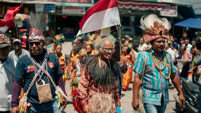 Vibrant cultural celebration with traditional clothing and flag in Papua, Indonesia.
