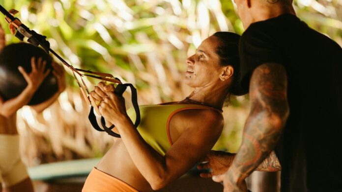 Fitness enthusiasts engaging in an outdoor functional training session with TRX and medicine ball.