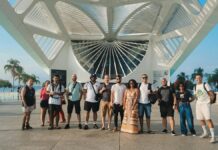 Secult-PB e UFPB lançam edital com vagas para bolsistas em museus da Paraíba A diverse group of tourists standing at the Museum of Tomorrow with modern architecture in the background.