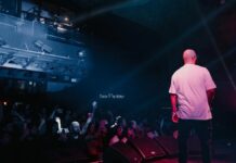 Pepsi e Diageo retiram patrocínio de festival de Kanye West em Londres Rapper performing live on stage with vibrant lighting and engaged audience in a concert setting.