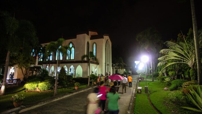 Igreja nas Filipinas iluminada por painéis solares em telhado, mesclando tradição religiosa e tecnologia sustentável.